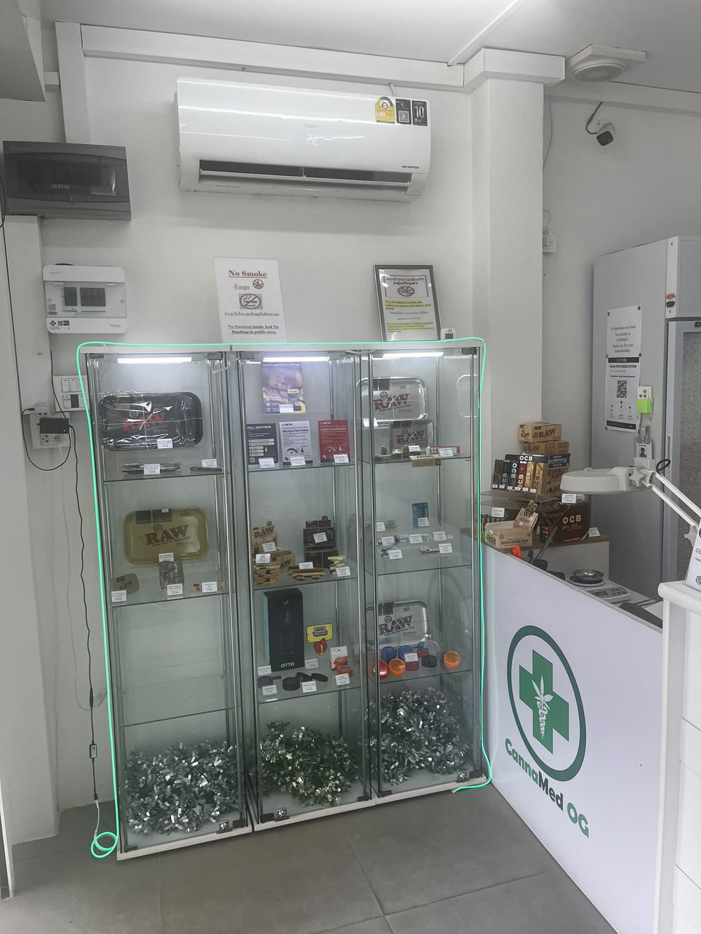 Glass display cases inside the white CannaMed OG dispensary in Lamai